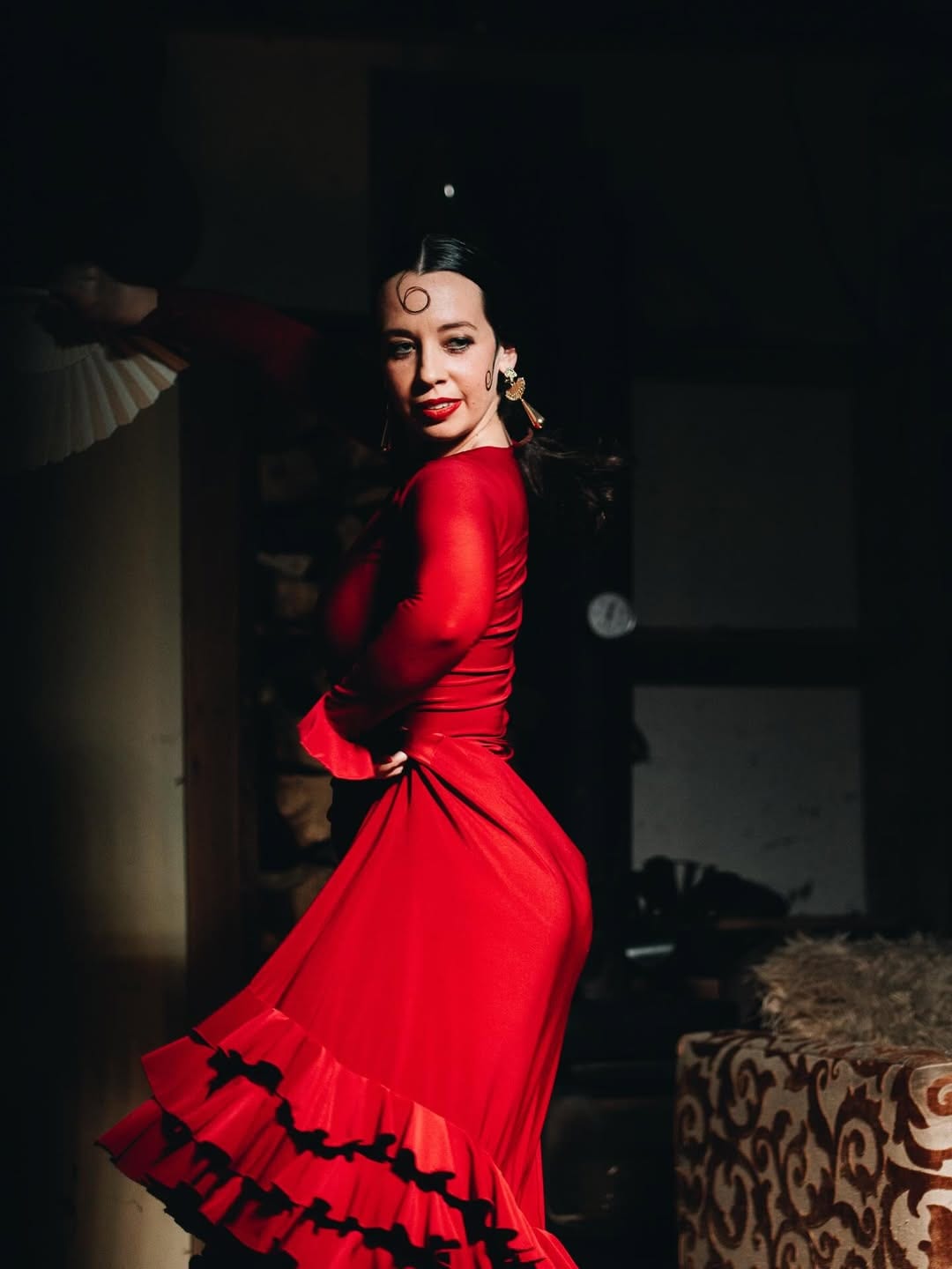 A flamenco dancer in a red ruffled dress at an El Payo night.
