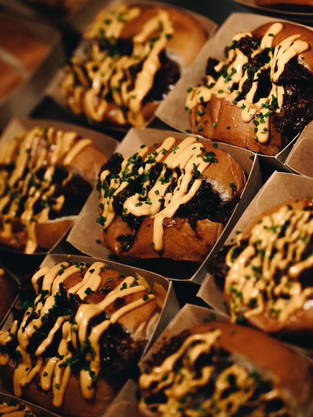 Trays of El Payo brioche montaditos topped with smoked-paprika mayo and chives.